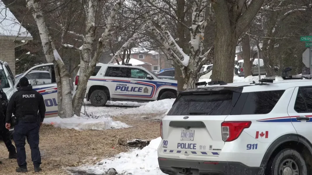 Police officers stand by the house in London, Ont., where four people are alleged to have been storing chemicals that could be made into explosives, on Monday. An RCMP team has joined the investigation. (Alessio Donnini/CBC)